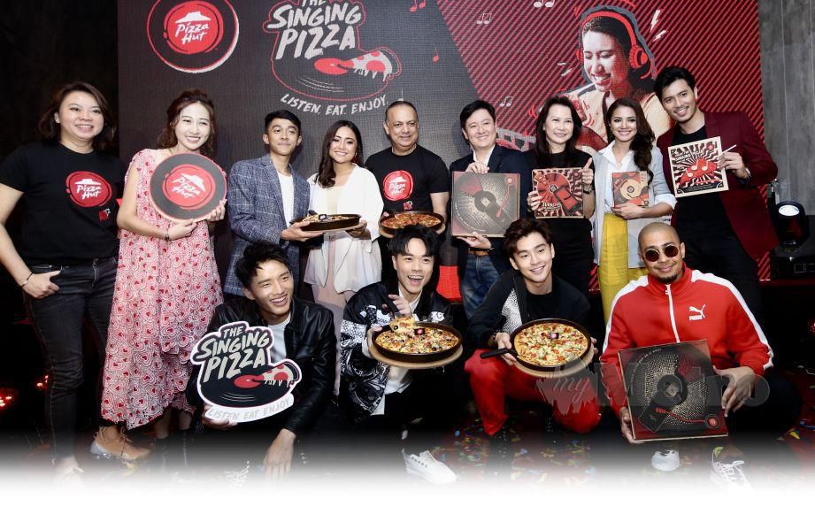 PEREYRA (berdiri, tengah) bersama selebriti pada pelancaran The Singing Pizza, kelmarin.