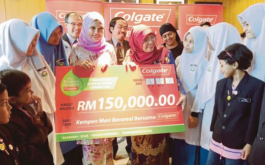  ROHANI (tengah) bersama Pengarah Pemasaran Kanan Colgate-Palmolive Malaysia Datin Nor Aziah beramah mesra dengan pelajar sekolah, semalam.  