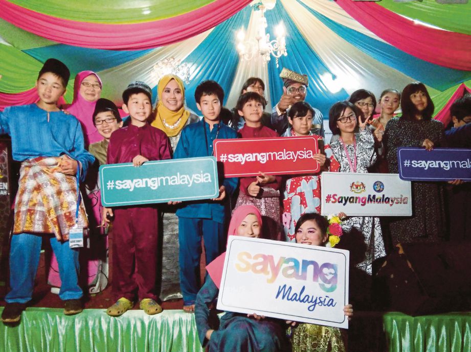 MAS Ermieyati bergambar bersama pelajar Jepun pada Program Silang Budaya di Inap Desa Kampung Paya Lebar. 