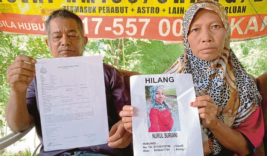 DAUD  dan Faridah  menunjukkan laporan polis  dan gambar Nurul Suriani yang hilang. 