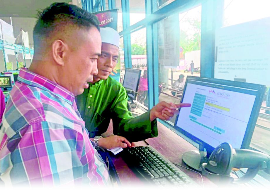 PENYELIA Operasi Ferry line Venture Kuala Kedah, Ahmad Azizan Aziz membantu pelanggan mengisi nama di komputer yang disediakan. 