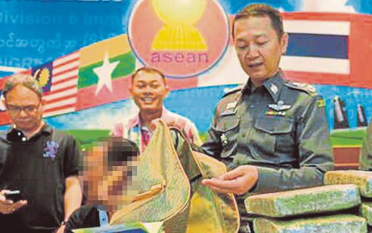 POLIS Thailand bersama suspek (kiri) dan dadah yang dirampas.