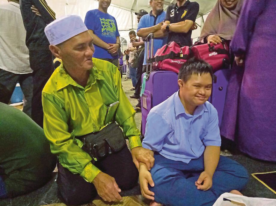 HAMZAH bersama  Afiq  yang menghidap sindrom down ketika ditemui di Kompleks Tabung Haji, semalam.
