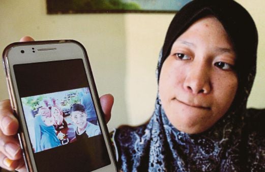 KAKAK mangsa, Nur Azatul Akhma Aris, 19, menunjukkan gambar arwah Muhammad Ajwad yang maut dalam kemalangan.