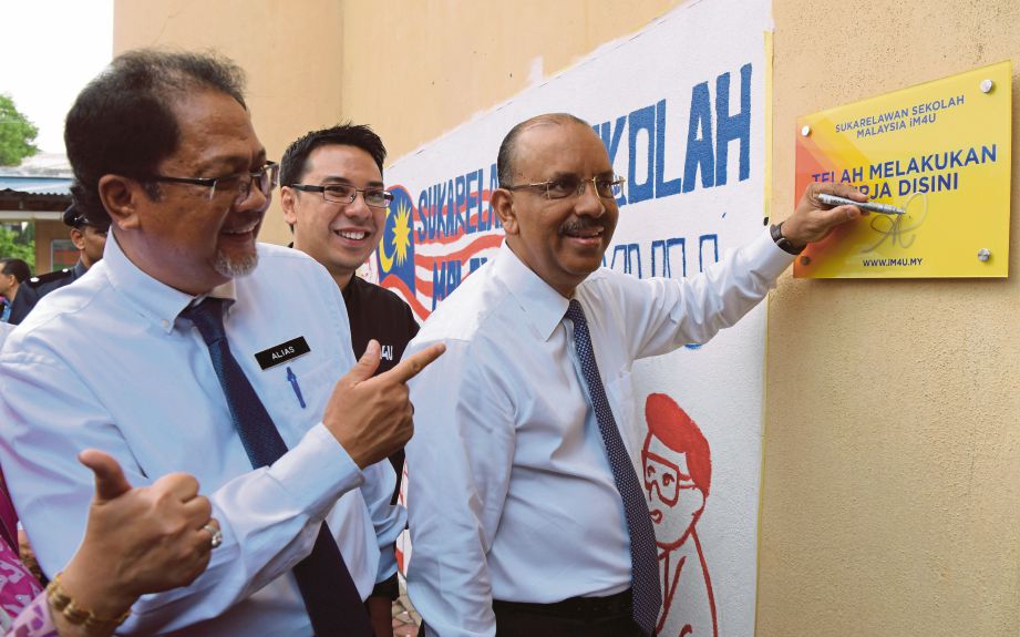  Ali  (kanan) menandatangani plak Program SSM  di SMK Putrajaya Presint 16, semalam.