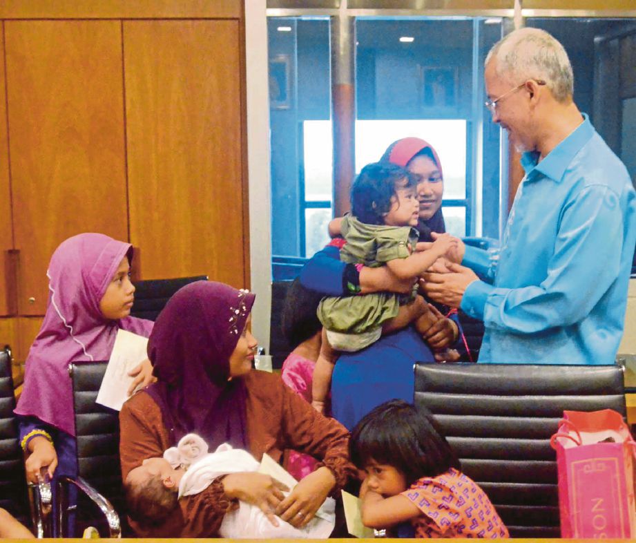 PENGURUS Besar Yayasan Pahang  Datuk Mahmud Mohd Nawawi bertemu dengan Ashniwati (duduk) dan anaknya di Kompleks YP selepas beli-belah baju raya. 