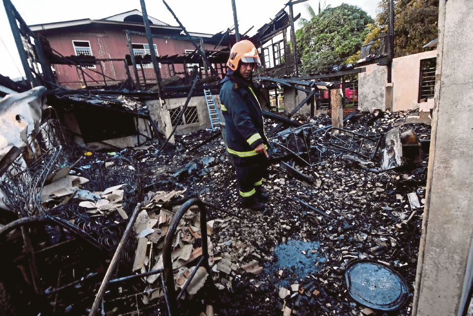 ANGGOTA bomba menunjukkan tempat Siti Nor Munirah dijumpai maut dalam kebakaran   rumah, semalam. 