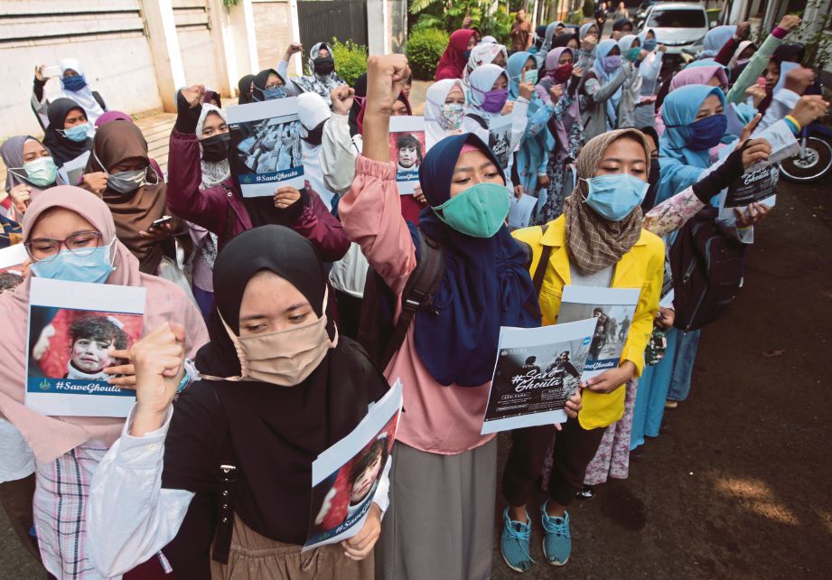 SEKUMPULAN pelajar berhimpun di hadapan kedutaan Syria di Jakarta, Indonesia semalam bagi membantah serangan tentera rejim itu ke atas penduduk Ghouta Timur. - EPA