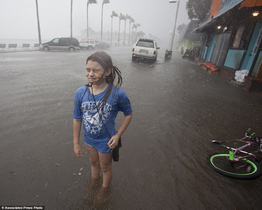 SEORANG kanak-kanak Hannah Coles, sembilan, terpaksa berhenti menunggang basikal meredah banjir apabila angin kencang membadai mukanya di Gulfport, Florida. - AP