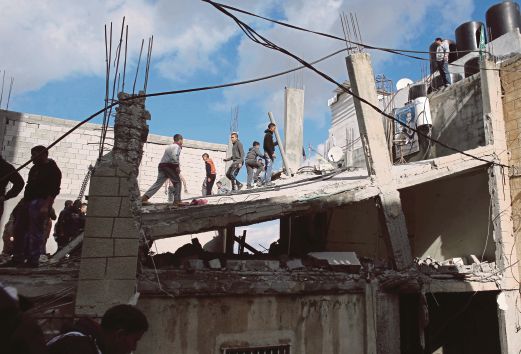 PENDUDUK memeriksa keadaan rumah Ibrahim selepas dimusnahkan.