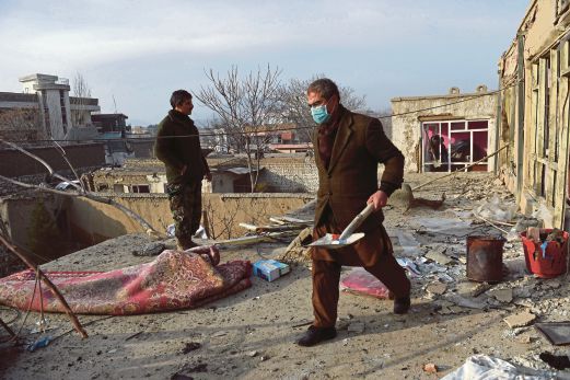 PENDUDUK membersihkan serpihan kaca dari rumah mereka yang terletak berhampiran restoran Perancis yang diserang di Kabul.