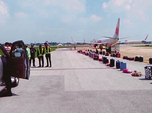 BEG milik penumpang pesawat Thai Lion Air disusun di atas landasan ketika pasukan pemusnah bom membuat pemeriksaan.