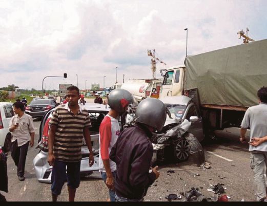   Orang ramai melihat kemalangan membabitkan lapan kenderaan di Simpang Kota Puteri dari Pasir Gudang menghala Johor Bahru, semalam. 