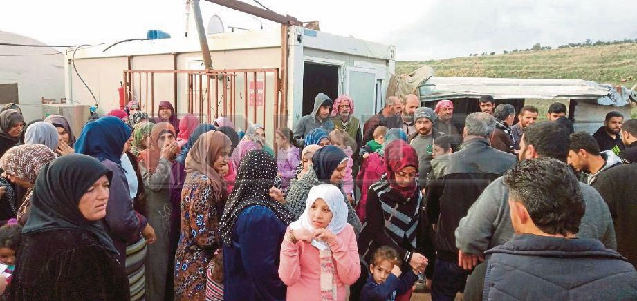 PELARIAN Syria bersabar menanti kedatangan sukarelawan Syria Care bagi mendapatkan bantuan makanan.