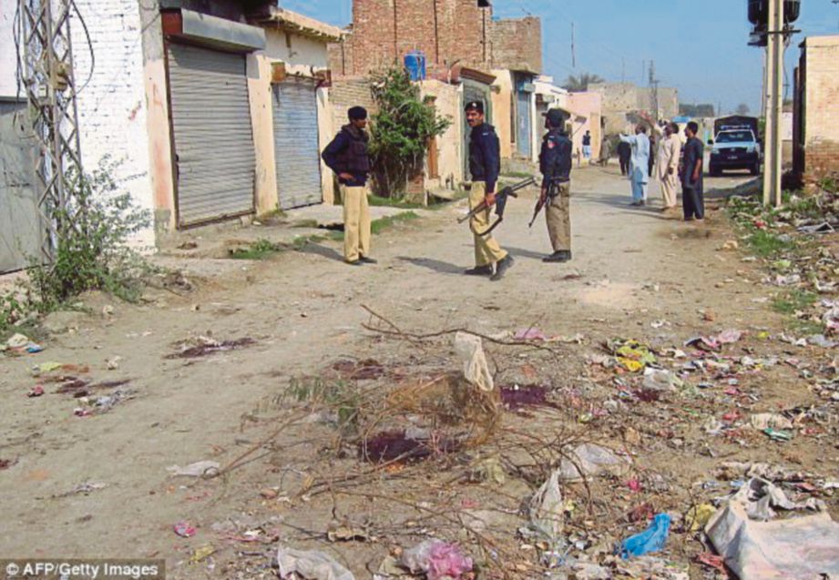 ANGGOTA polis berkawal di sebatang jalan di kampung Garahmat, Dera Ismail Khan di Pakistan. - AFP