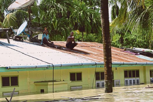 PENDUDUK melambai dari bumbung sebuah rumah yang tenggelam di Kalay di utara Myanmar, semalam.  