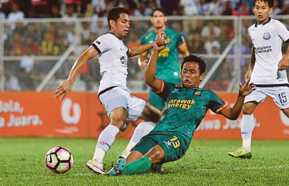 FERRIS DANIAL (kiri) diasak pemain Sarawak Dzulazkan Ibrahim di Stadium Sultan Ismail Nasiruddin Shah, Kuala Terengganu.
