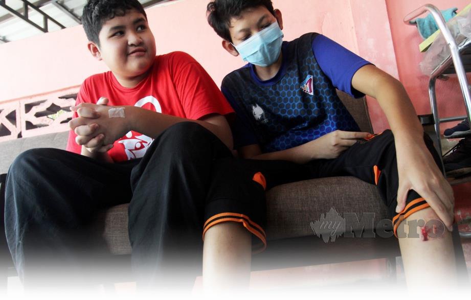 SYAFIQ (kanan)  bersama Muhammad Nafiz menunjukkan kesan luka ketika kejadian yang meragut nyawa nenek mereka. 