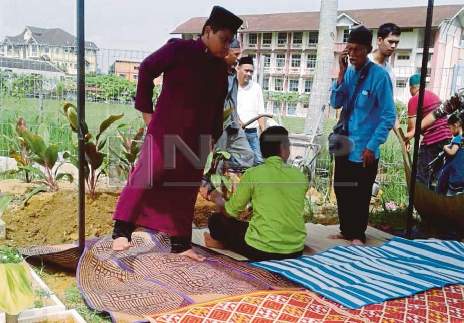 MUHAMMAD Iman ketika pengebumian arwah ibunya di Tanah Perkuburan Sungai Kantan.