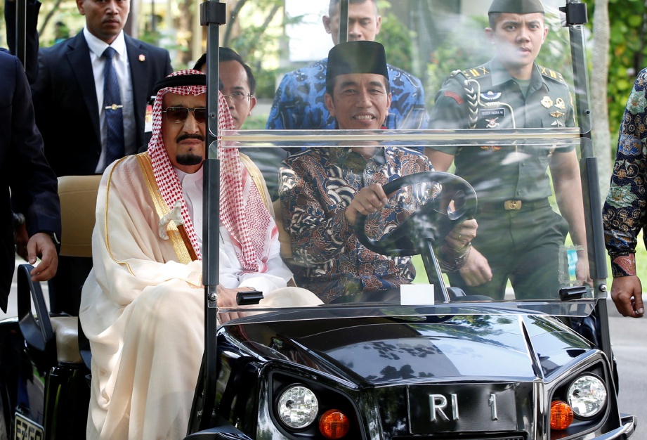 RAJA Salman menaiki kereta bugi yang dipandu Presiden Joko Widodo di Istana Presiden di Jakarta, semalam. - Reuters