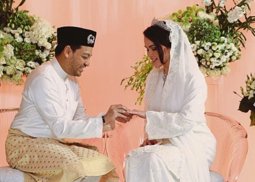 TUNKU  Nadzimuddin  menyarungkan cincin perkahwinan di jari    Sarimah.    