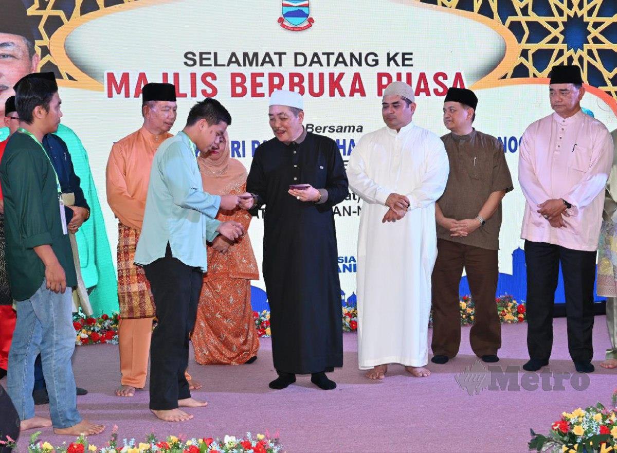 Ketua Menteri Sabah, Datuk Seri Hajiji Noor (tengah) menyampaikan sumbangan kepada asnaf pada majlis berbuka puasa di Tuaran. FOTO Ihsan Jabatan Ketua Menteri Sabah