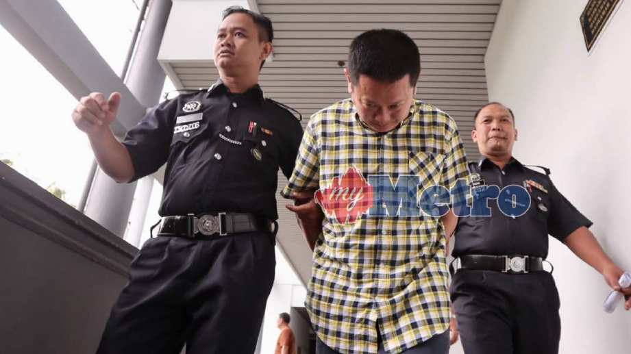 NG Ngui Kee, 44, dari Kuching, Sarawak diiringi anggota polis keluar dari mahkamah selepas mengaku tidak bersalah atas pertuduhan menawarkan kontrak membekal beras yang tidak wujud ketika dihadapkan ke Mahkamah Majistret di Kompleks Mahkamah Melaka, Ayer Keroh. FOTO Rasul Azli Samad