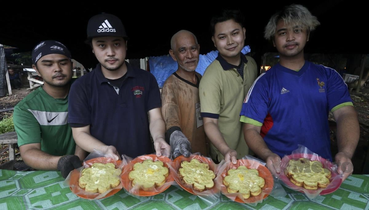 ROSLAN (tengah) dibantu empat anaknya (dari kiri) Zarul Ikhwan, Zazuan Haqeem, Zakry Syafiq dan Muhammad Zam Firdaus menjual kuih menganang di Kampung Bukit Bayas, Kuala Terengganu. FOTO GHAZALI KORI