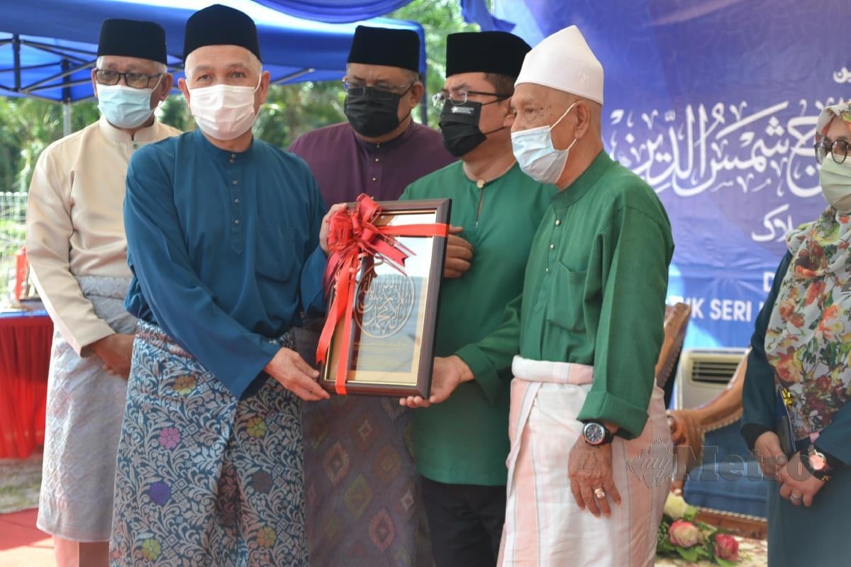 Ghazali Othman (kiri) dan Ramli Ahmad (kanan) menerima cenderahati daripada Sulaiman Md Ali pada majlis perasmian Sekolah Rendah Agama (SRA) Ujong Padang, Kuala Sungai Baru Masjid Tanah. FOTO Hassan Omar