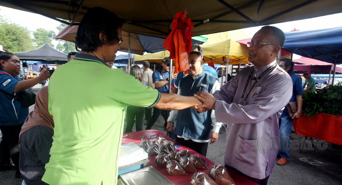 Calon PN, Khairul Azhari Saut (kanan) beramah mesra peniaga ketika walkabout di Pasar Pagi Batang Kali sempena Pilihan Raya Kecil (PRK) DUN Kuala Kubu Bharu. FOTO HAIRUL ANUAR RAHIM