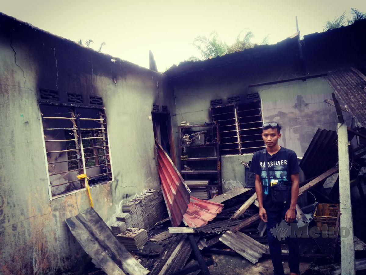 Norazizi Omar di samping rumah kediamannya yang musnah terbakar di Kampung Tenggayun, Pontian.FOTO TOGI MARZUKI