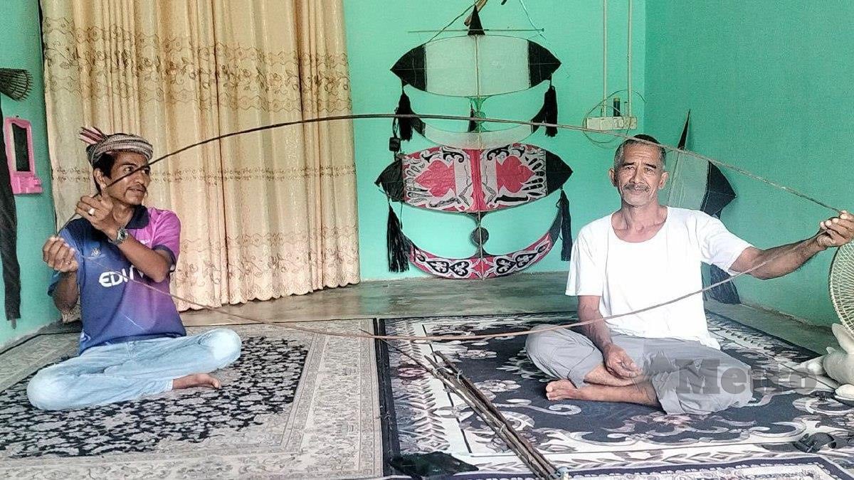 Mohamad Wahab, 38, (kiri) dan Abdul Wahab Che Amin, 58, menunjukkan rangka wau berusi lebih setengah abad yang diwarisi daripada arwah bapanya. FOTO Noorazura Abdul Rahman