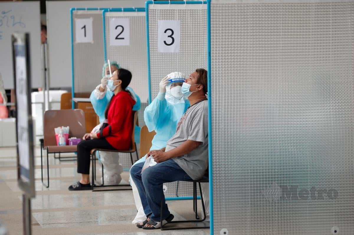 PETUGAS kesihatan melakukan ujian calitan kepada orang awam di Bangkok, Thailand. FOTO EPA