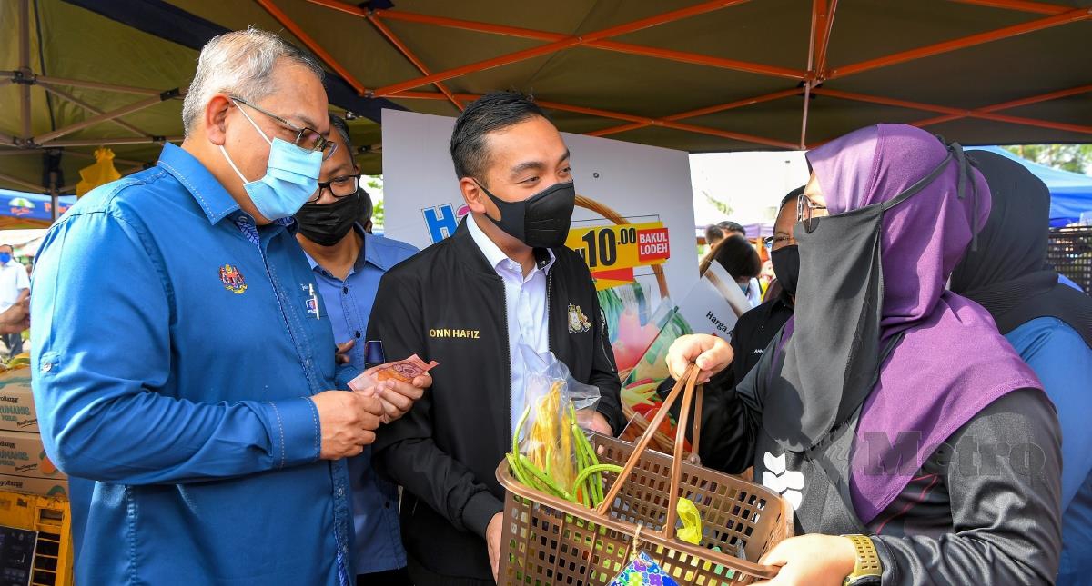 Menteri Besar Johor Datuk Onn Hafiz Ghazi (tengah) menyampaikan Happy Hour Bakul Lodeh RM10 kepada pembeli yang hadir pada Majlis Pelancaran Program Jualan Semarak Syawal FAMA 2022 di Pasar Tani Datin Halimah semalam. FOTO BERNAMA