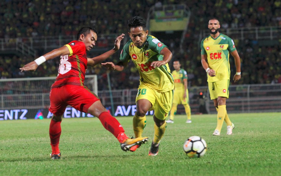 PEMAIN Negeri Sembilan, Mohd Khairul Izuan Rosli mengekang kepantasan Andik Vermansah (kanan) di Stadium Darul Aman. -FOTO SHARUL HAFIZ ZAM