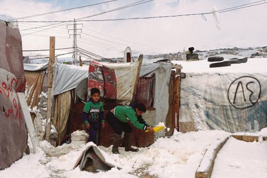 PELARIAN kanak-kanak Syria membuang salji di hadapan khemah keluarga mereka.
