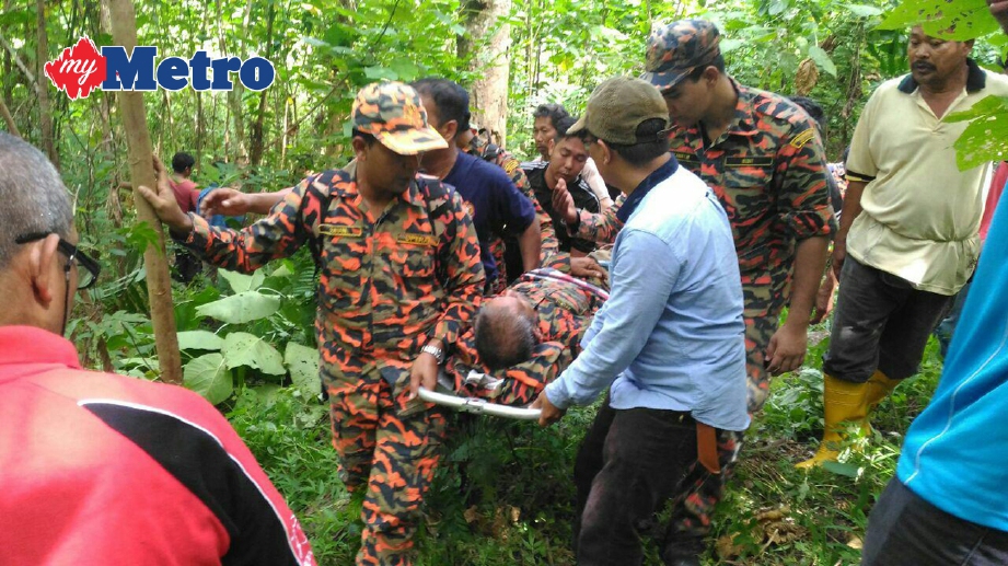 ANGGOTA bomba dan penduduk membawa turun Harun Yaakob, 64, dari Bukit Pongsu kira-kira 200 meter dari Kampung Keda Telok Teduri, Pulai. FOTO Safuri Kamarudin