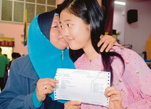 SANYA menerima ciuman daripada Pengetuanya, Norini Wan Awang selepas mengambil slip keputusan SPM di SMK Kedawang, semalam.