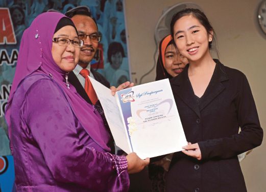  KETUA Sektor Pengurusan Akademik Fouziah Buang (kiri) menyampaikan sijil pelajar cemerlang SPM kepada Cheryl  di Majlis Pengumuman Keputusan Peperiksaan SPM Tahun 2014 di Jabatan Pendidikan Selangor. 