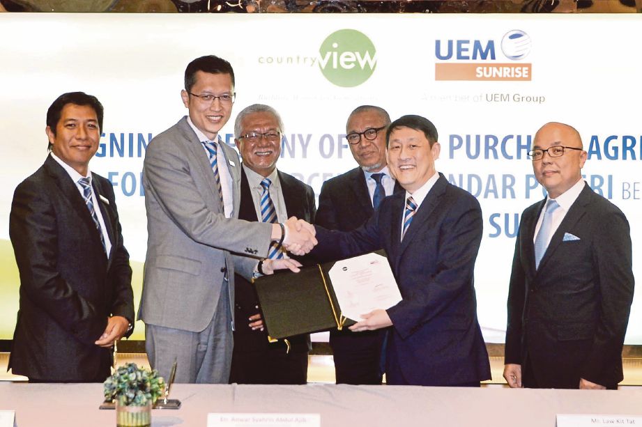 ANWAR    (dua dari kiri) bertukar dokumen perjanjian dengan Pengarah Eksekutif Country View, Law Kit Tat  pada majlis menandatangani perjanjian jual beli tanah bagi pembangunan komersial di UEM Sunrise Showcase Mont Kiara, Kuala Lumpur.