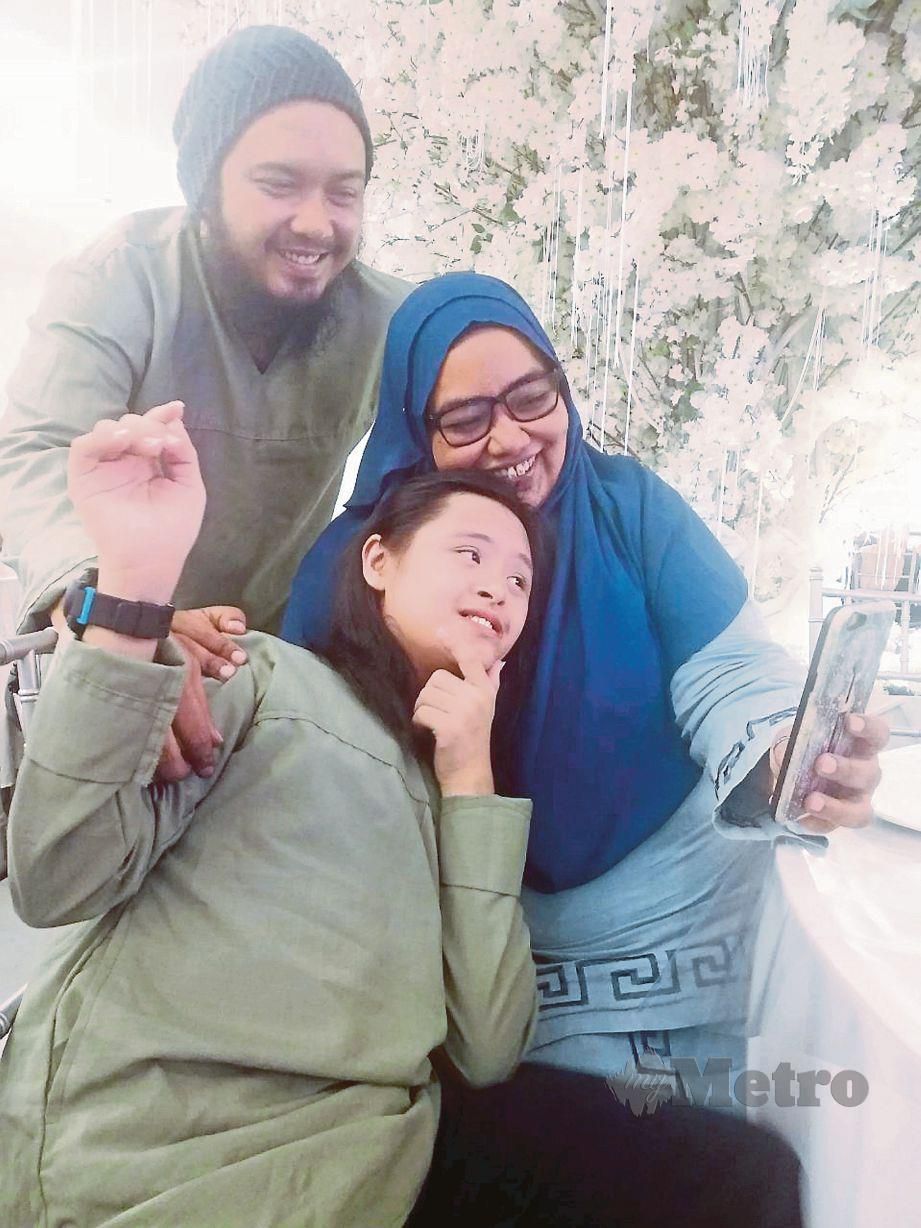  SARIMAH dan Shahril berswafoto dengan Muhammad Ilyas yang mengalami sindrom Down sejak lahir. 