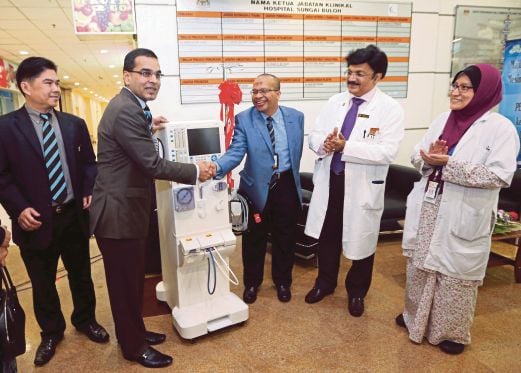 DR Mohammed Azman  (kiri) menyampaikan mesin hemodialisis kepada Dr Khalid sambil diperhatikan Dr Jeyaindran.