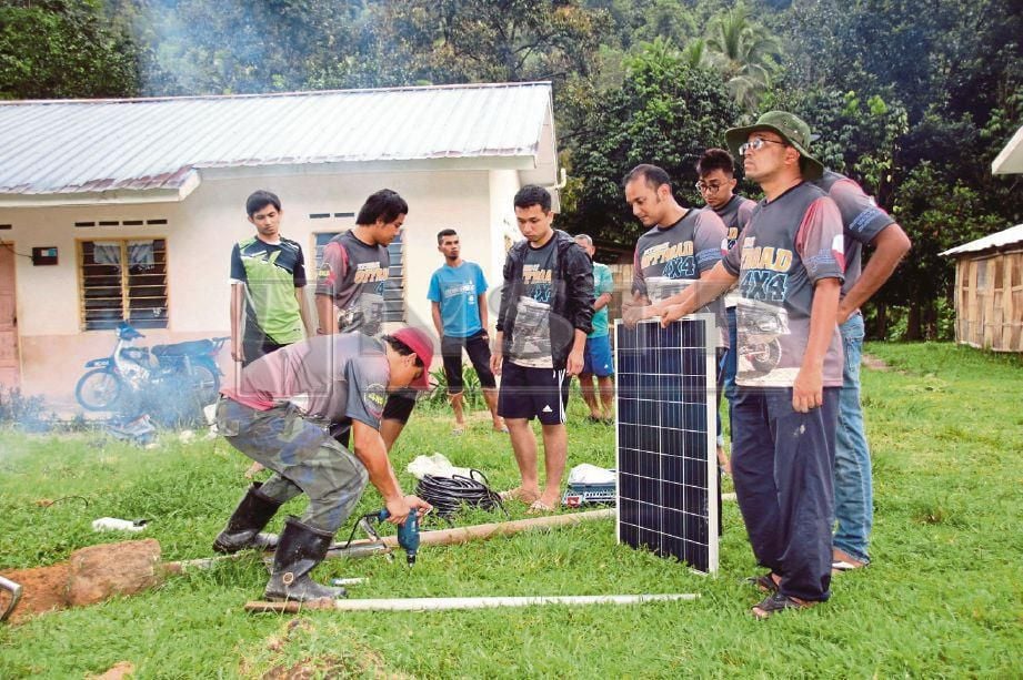 PESERTA program membantu memasang pam solar.