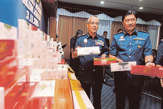 RAMLI (kiri) dan Timbalan Pengarah Kastam Johor, Zulkurnain Mohd Yusof Zulkurnain menunjukkan rokok seludup yang dirampas bernilai RM13.55 juta.