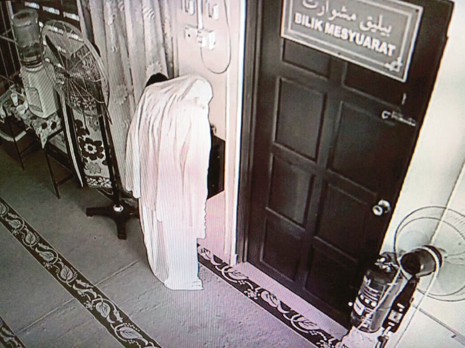 Rakaman CCTV perbuatan suspek memakai telekung mengeluarkan wang dari tabung masjid.