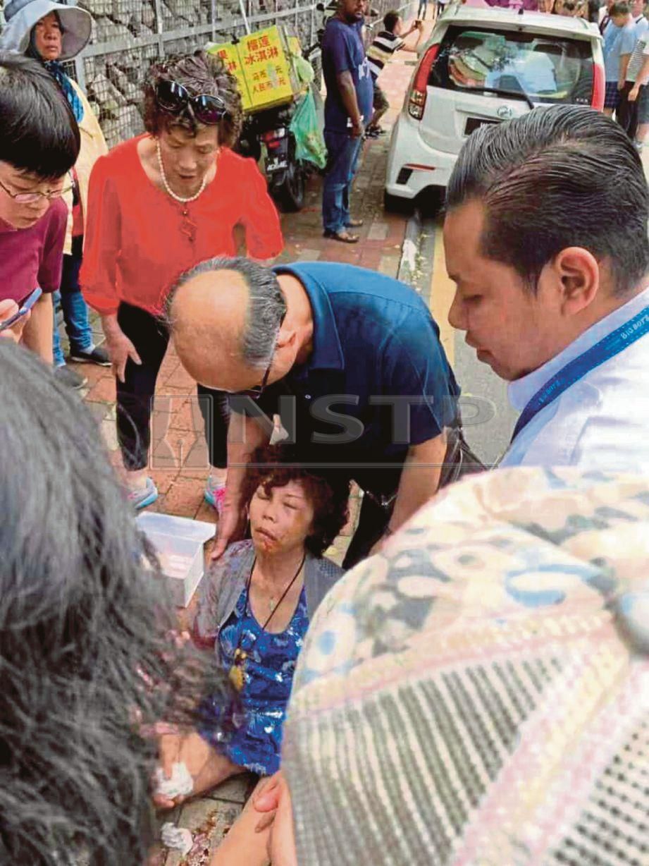 WANITA pelancong China cedera di kepala dan muka  diragut lelaki bermotosikal dibantu orang awam bagi mendapatkan rawatan. 