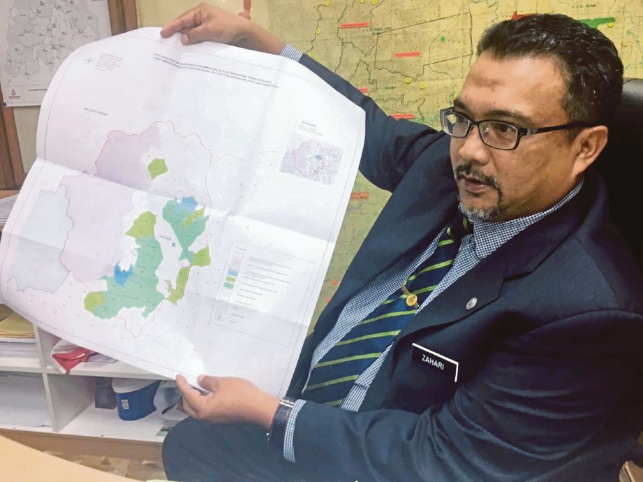ZAHARI menunjukkan peta Hutan Simpan Balah di Gua Musang. 