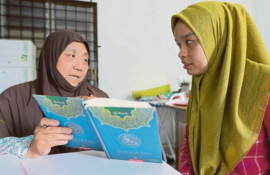NOR Asikin (kiri) membimbing Nur Hidayah mengaji al-Quran.