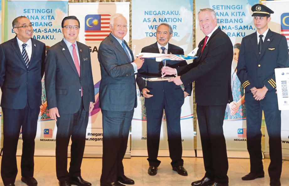 NAJIB menerima cenderahati daripada Bellew (dua dari kanan) selepas majlis pengumuman Malaysia Airlines sempena Inisiatif Negaraku di Putrajaya, semalam.