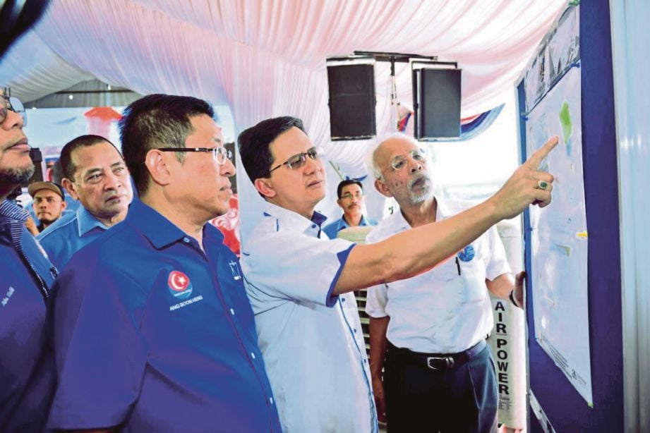 AMRAN (tengah) diiringi calon BN Parlimen Johor Bahru, Tan Sri Shahrir Abdul Samad (kanan) mengadakan lawatan  pada Majlis Pecah Tanah Dewan Muafakat Johor di Kampung Bakar Batu, Johor Bahru.